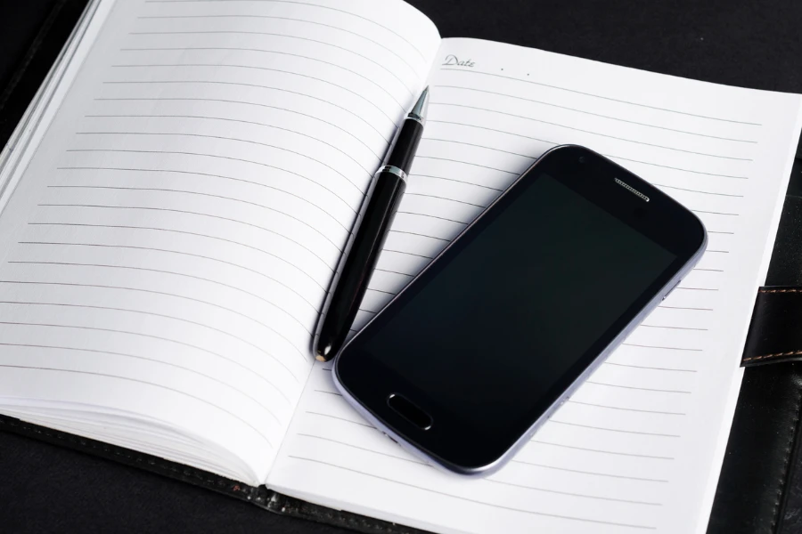 Teléfono móvil con bolígrafo en el cuaderno