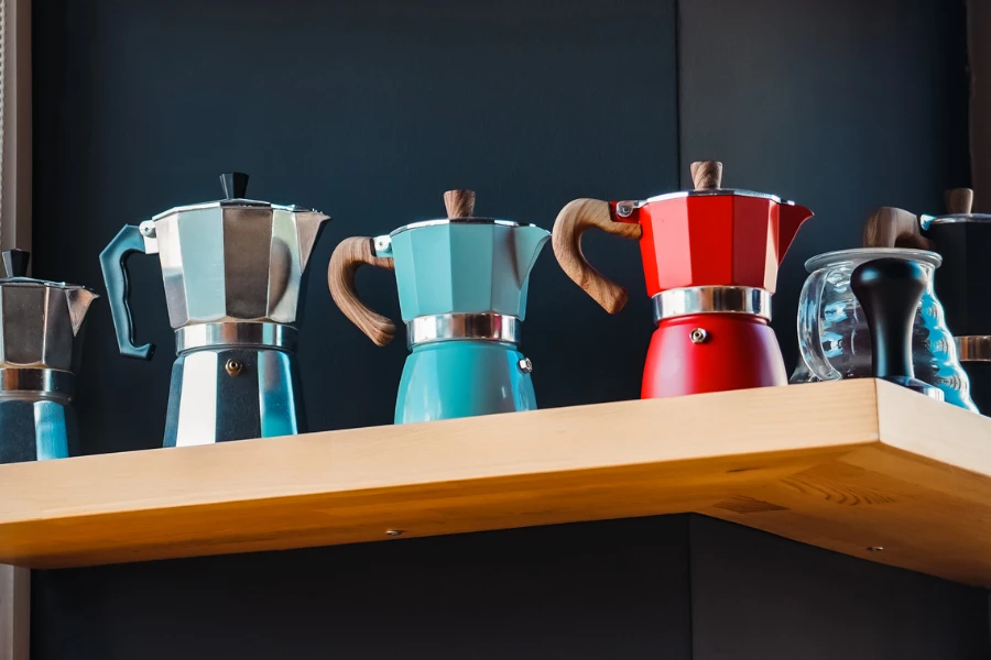 Moka pots in various colors and sizes on a shelf