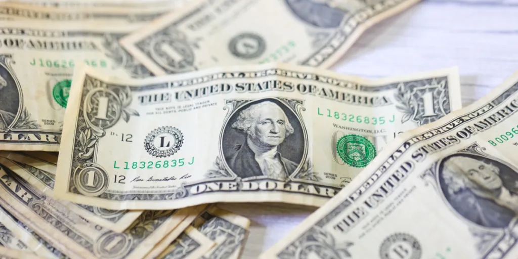 Uang kertas satu dolar tersebar di permukaan datar