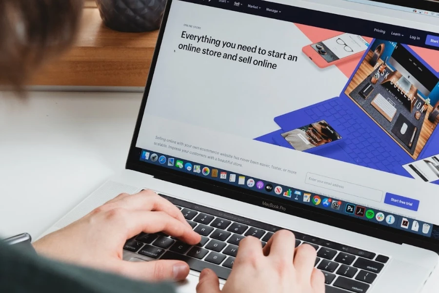 Person in front of a laptop with the Shopify homepage open
