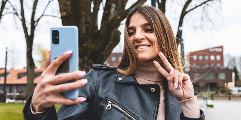 Pessoa tirando uma foto ao ar livre com um telefone em uma capa resistente