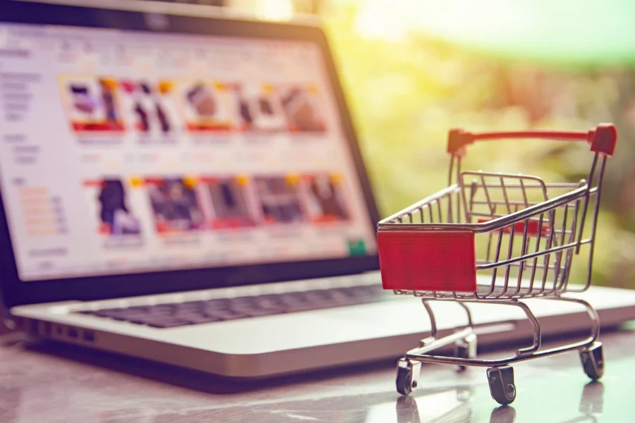 Shopping cart next to a laptop