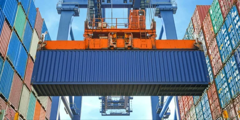 Shore crane loading containers in freight ship