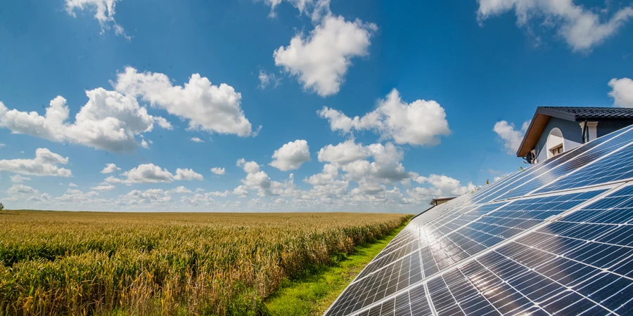 painéis de energia solar perto de um campo de trigo e céu nublado