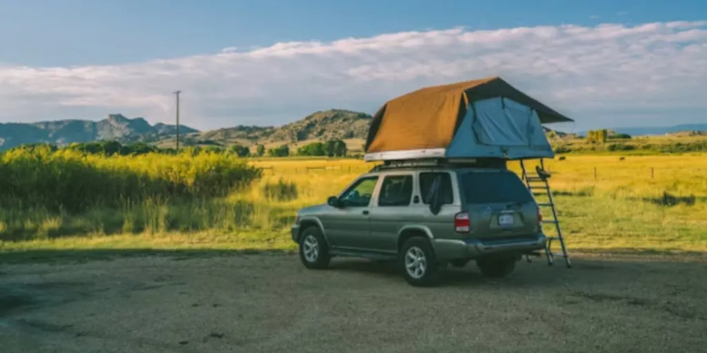 SUV garé en campagne avec tente sur le toit attachée