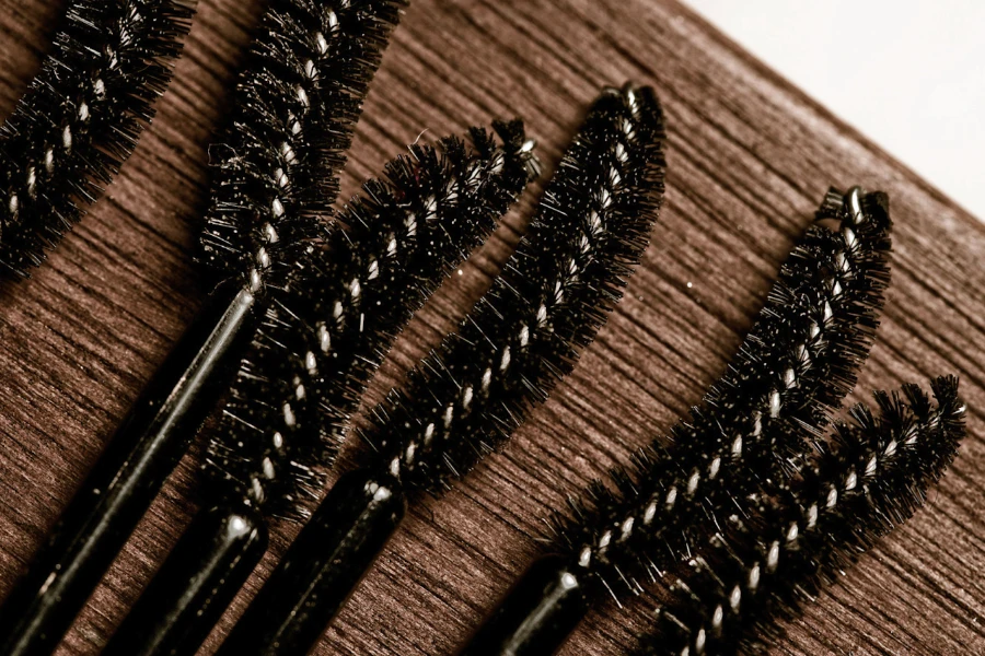 Diverses baguettes de mascara en fibres épaisses sur une table marron