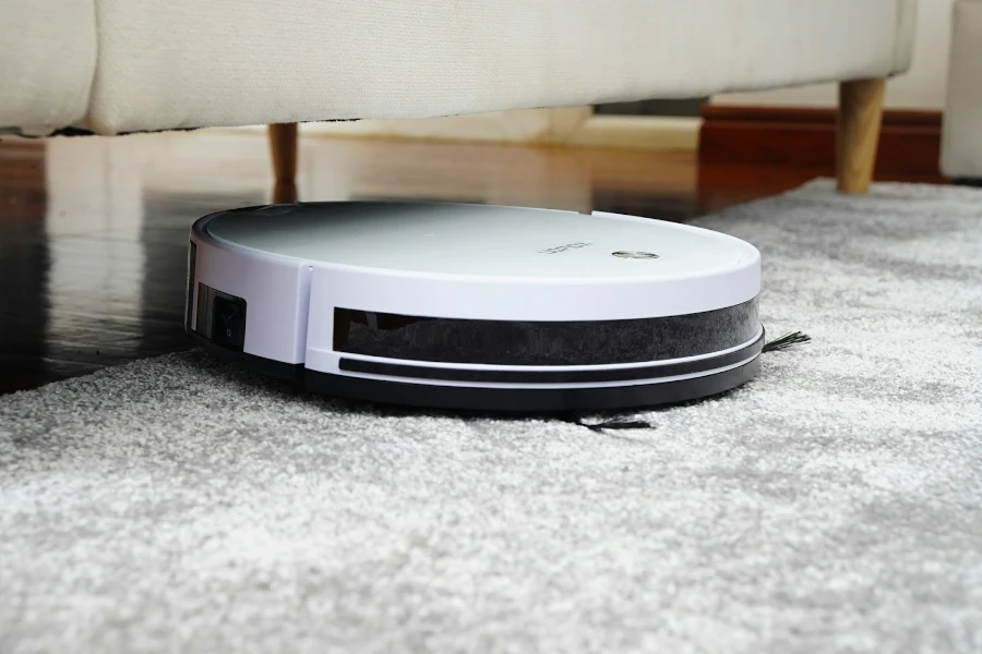 Белый робот-пылесос залез под диван