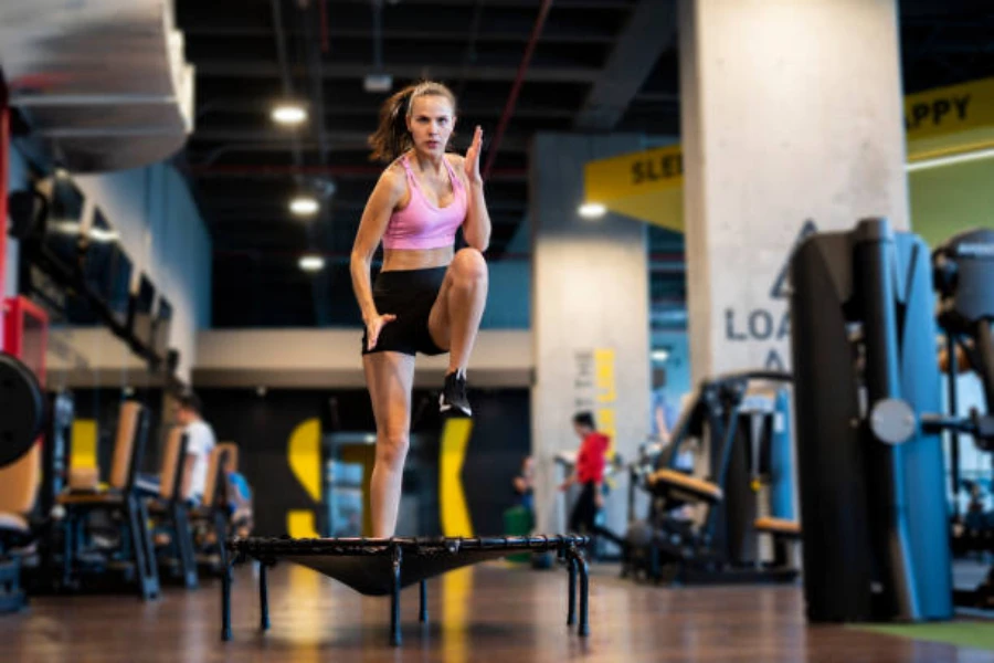 Woman jumping on exercise trampoline in a gym setting