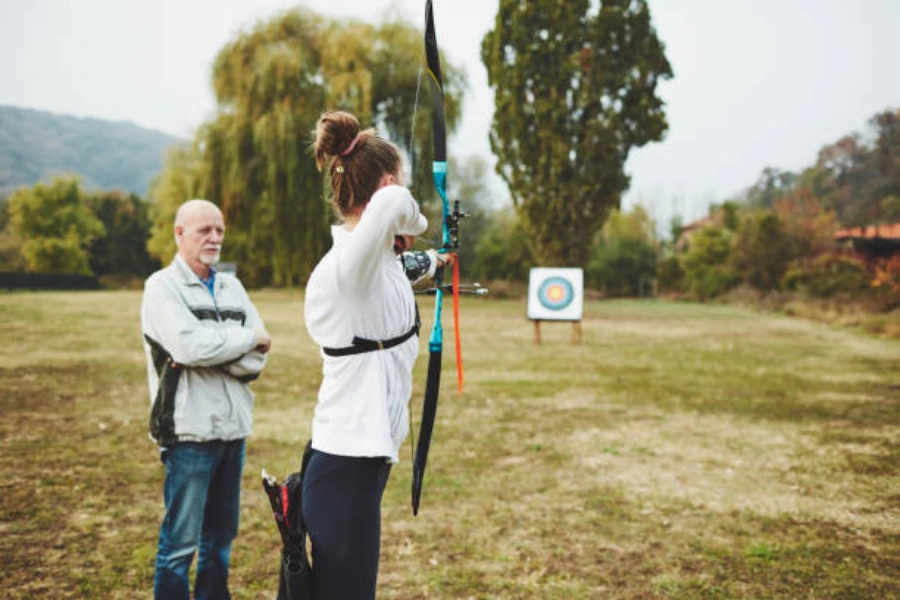 Woman lining up arrow to shoot at long-distance target