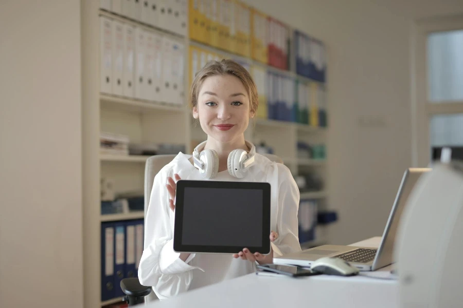 Woman looking straight forward holding a tablet