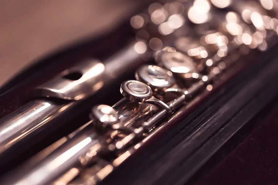 A close up portrait of a valve of a disassembled metal silver flute 