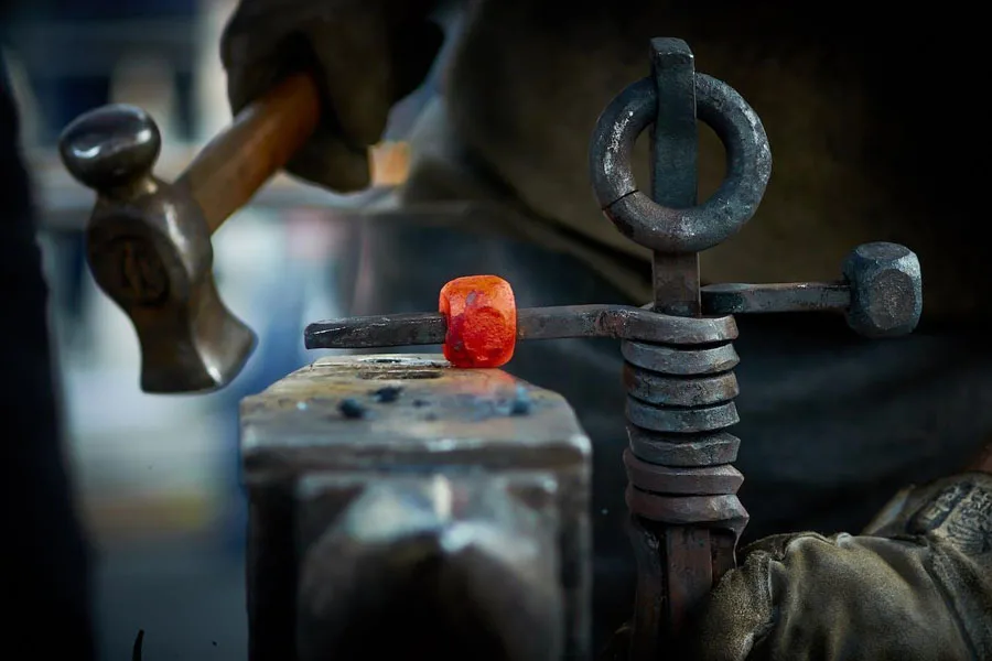 Seorang pengrajin yang mengerjakan kerajinan logam antik industri