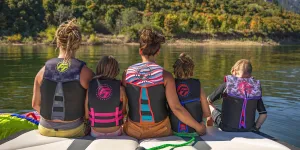 A family wearing life jackets on a lake