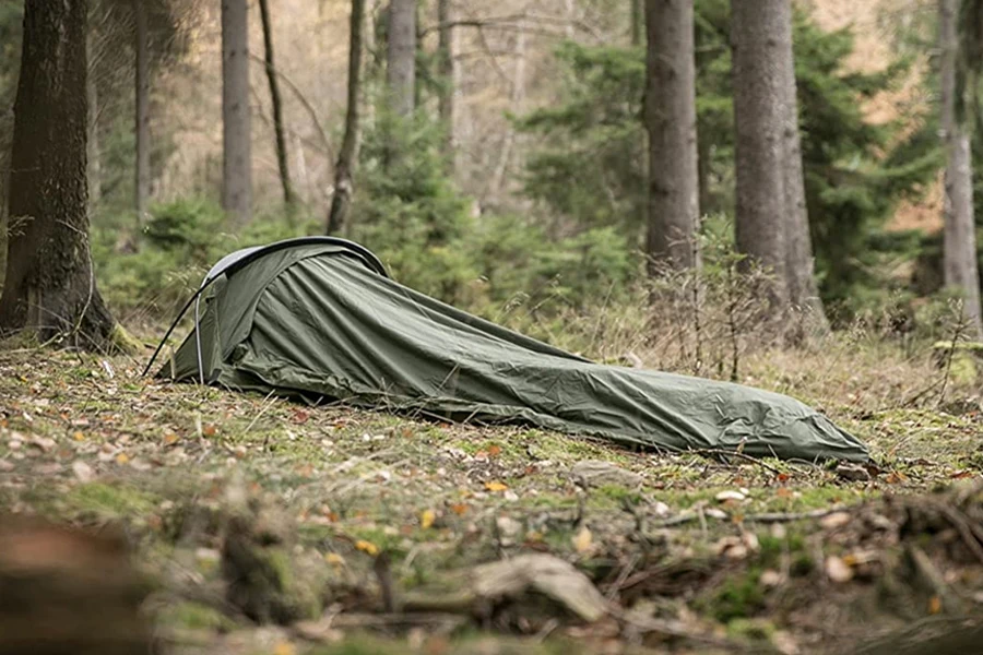A green bivy bag in a forest