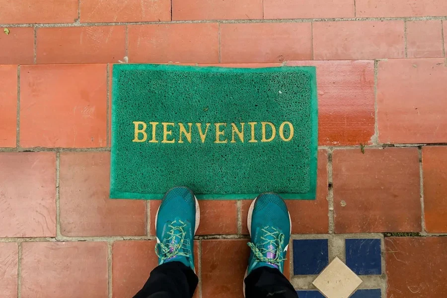 A green outdoor welcome doormat