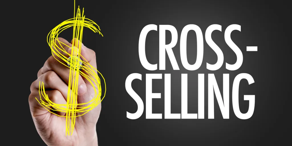 A hand writing the text cross-selling