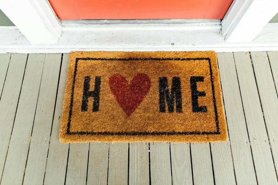 A light brown doormat with home and love text