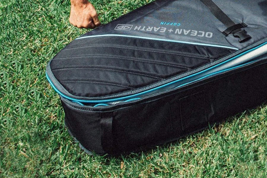 A multi-surfboard travel bag on grass