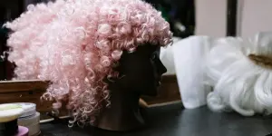 Wig keriting merah muda di kepala manekin