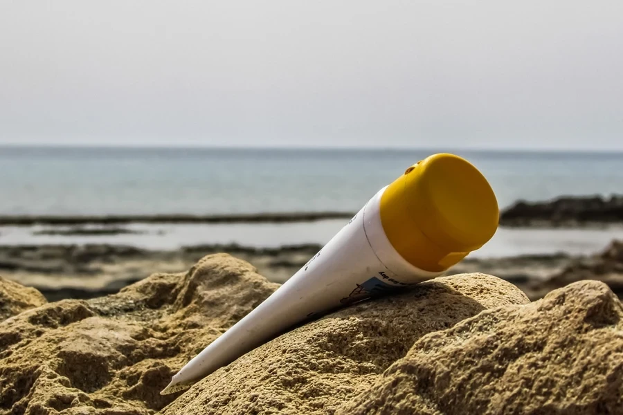 Una loción bronceadora sobre la arena de la playa.