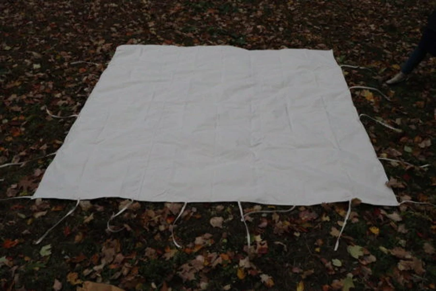 A white ground tarp laid out on the ground
