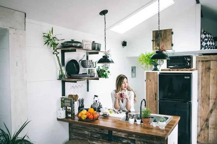 A woman drinking tea in a small kitchen