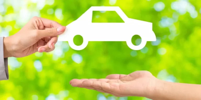 La mano de una mujer pasando un papel blanco con forma de coche.