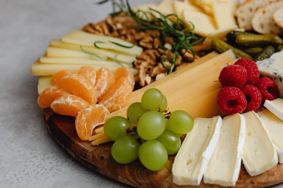 Una bandeja de madera llena de snacks saludables.