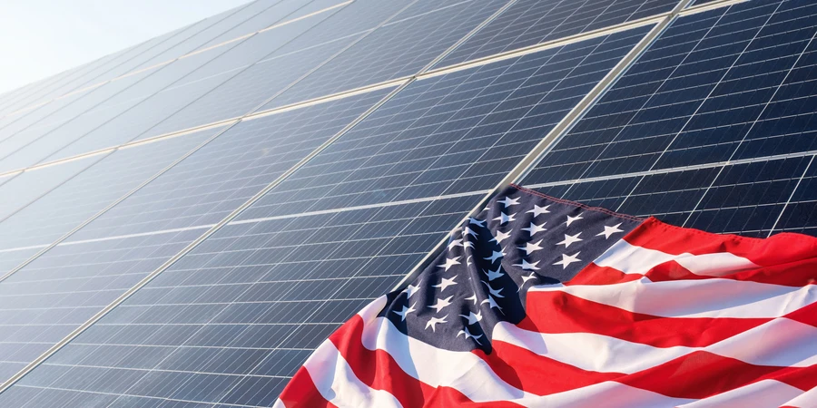 太陽光発電所のソーラーパネルにアメリカ国旗をクローズアップ