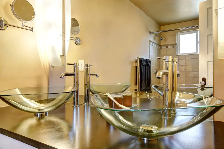 An acrylic vessel sink on a bathroom countertop