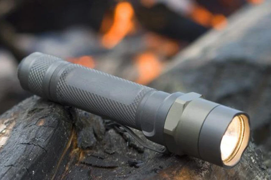 An activated camping flashlight on a rock