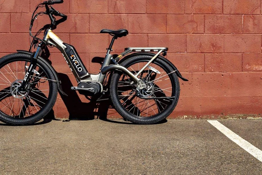 Sebuah sepeda listrik diparkir di dekat dinding bata