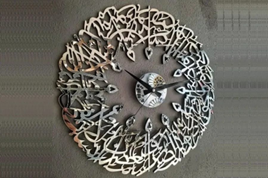 An ornate silver metal, mirror, and glass Islamic wall clock