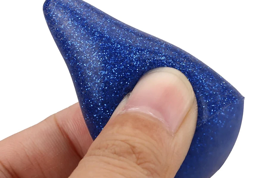 Mão anônima segurando o sopro cosmético de silicone azul