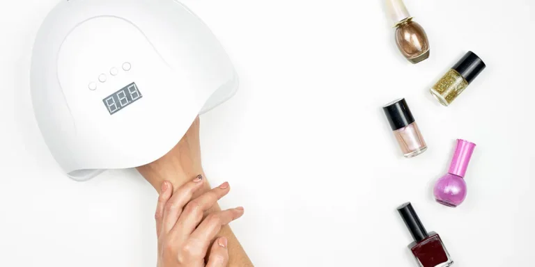 Anonymous person using a white nail dryer