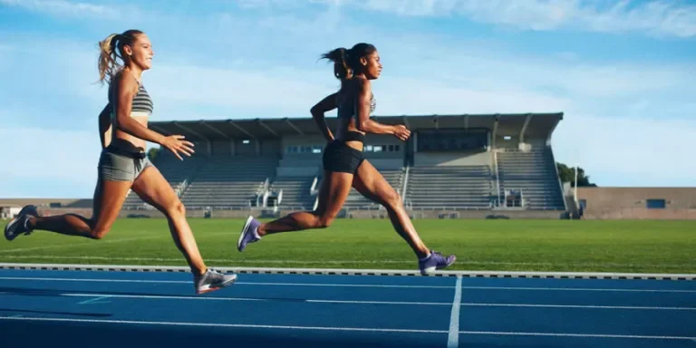 Athletes arrives at finish line on racetrack