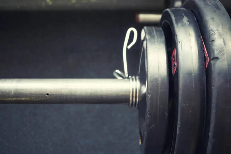 Barbell spring collar next to set of plates on bar