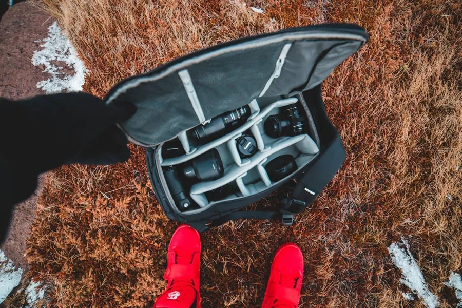 Camera case sitting on the ground at a person’s feet