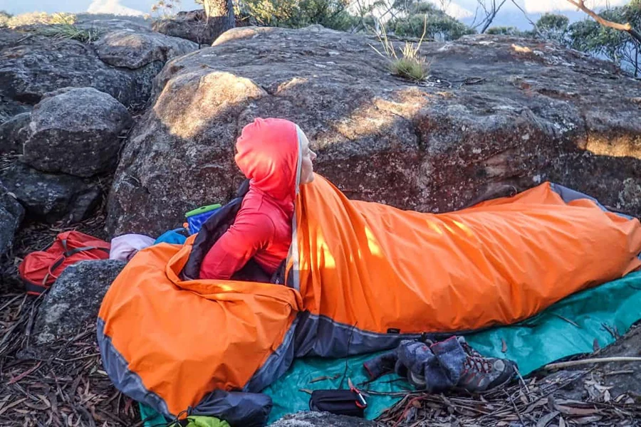 Camper in an orange bivy bag