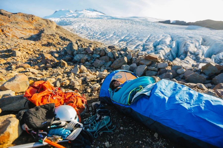 Camper schläft in einem blauen Biwaksack