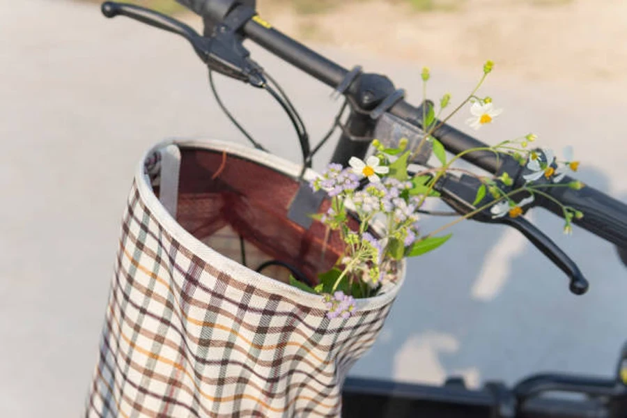 中に花が入ったキャンバス製の自転車かご