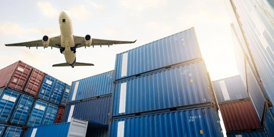 Cargo airplane flying above stack of logistic container