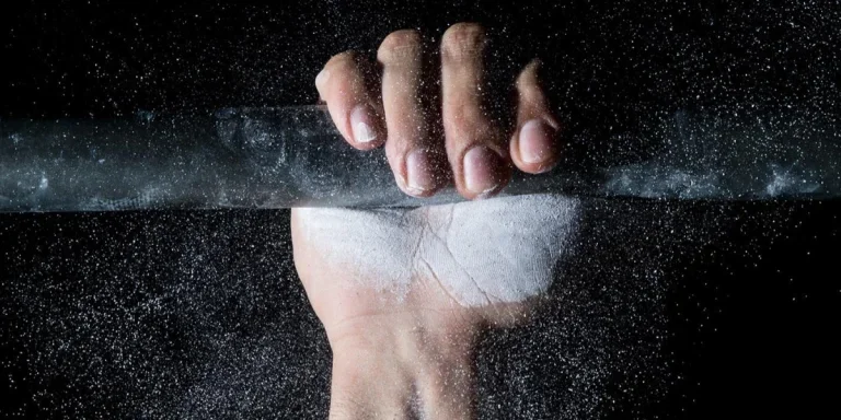 Chalked hand gripping a bar