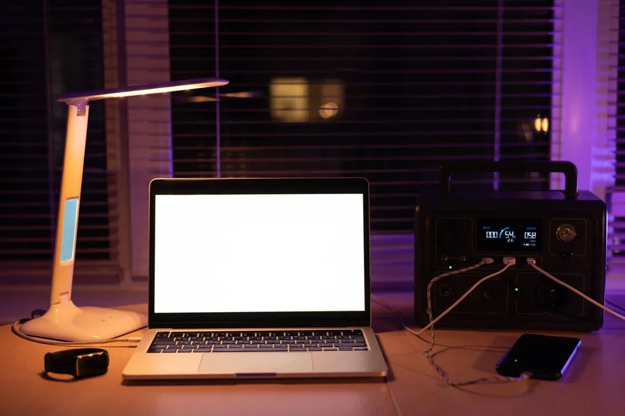 Estação de carregamento com laptop e luminária de mesa durante blackout