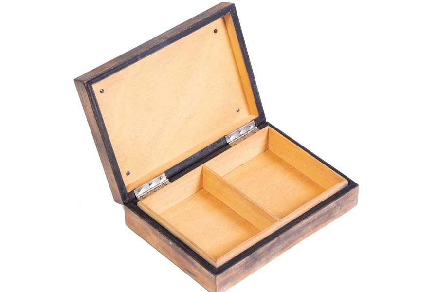 Rokok dalam kotak kayu tua diisolasi dengan latar belakang putih.