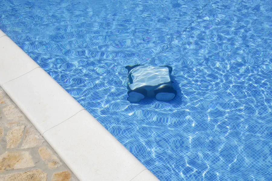 Reinigen des Poolbodens mit einem Unterwasserstaubsauger