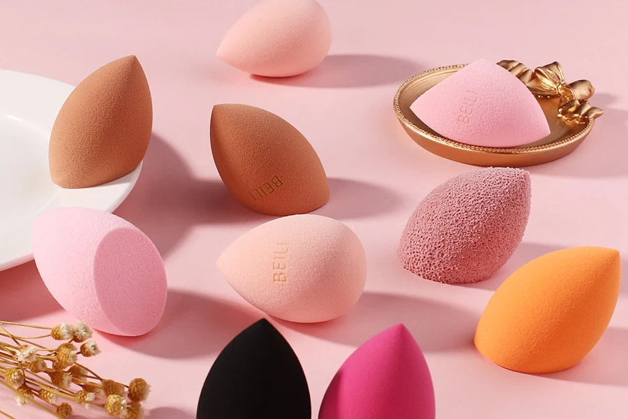 Puffs cosméticos coloridos em uma mesa rosa