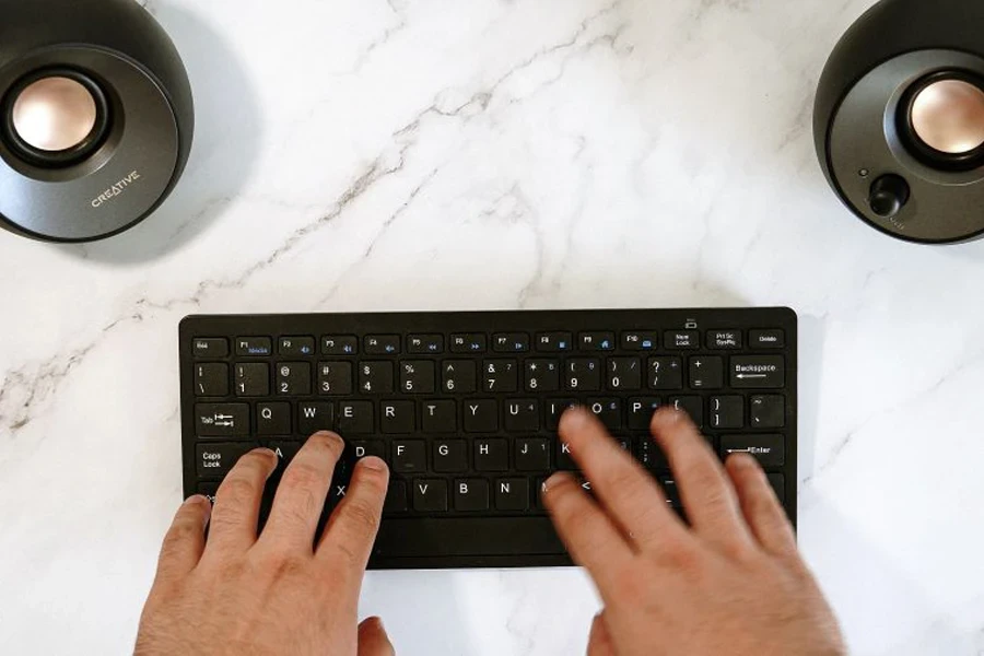 Creative Pebble speakers and a keyboard on white table