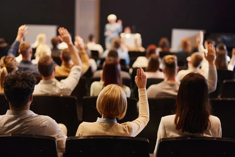 Crowd of people raising their hands at a gathering