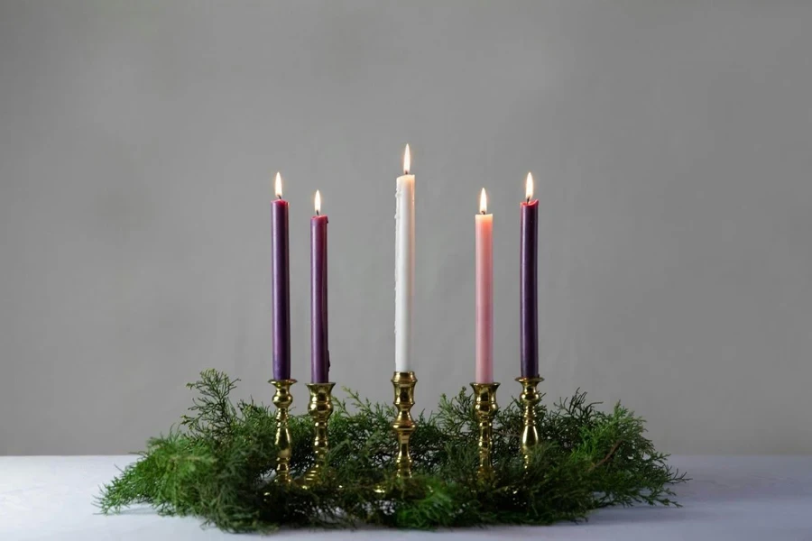 Four golden candle holders on a table.